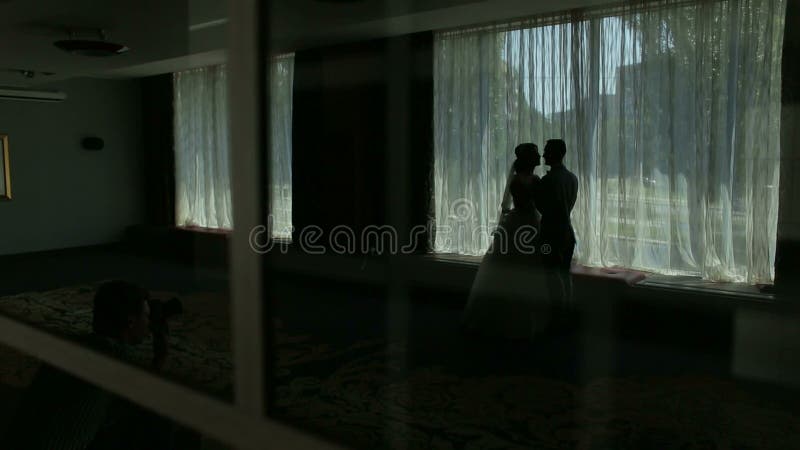 在窗口附近的浪漫夫妇剪影 衣物夫妇日愉快的葡萄酒婚礼